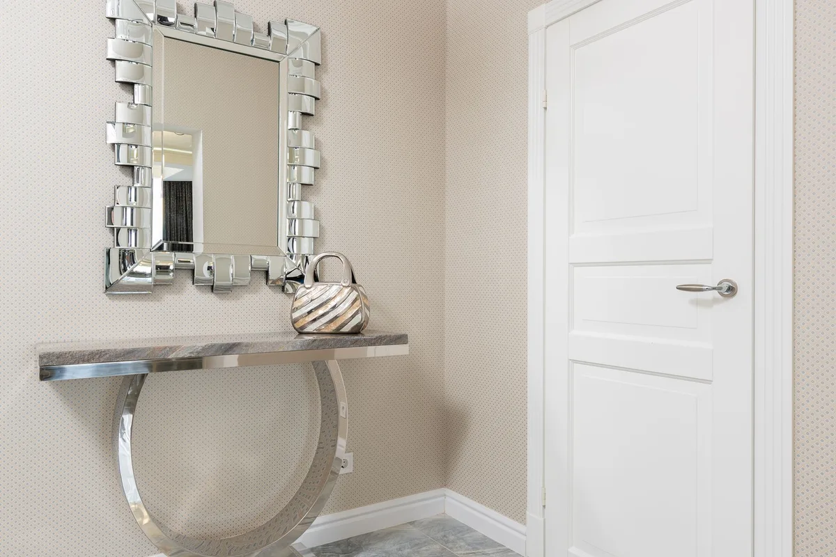 Entrée minimaliste avec console, miroir et accessoires de rangement discrets