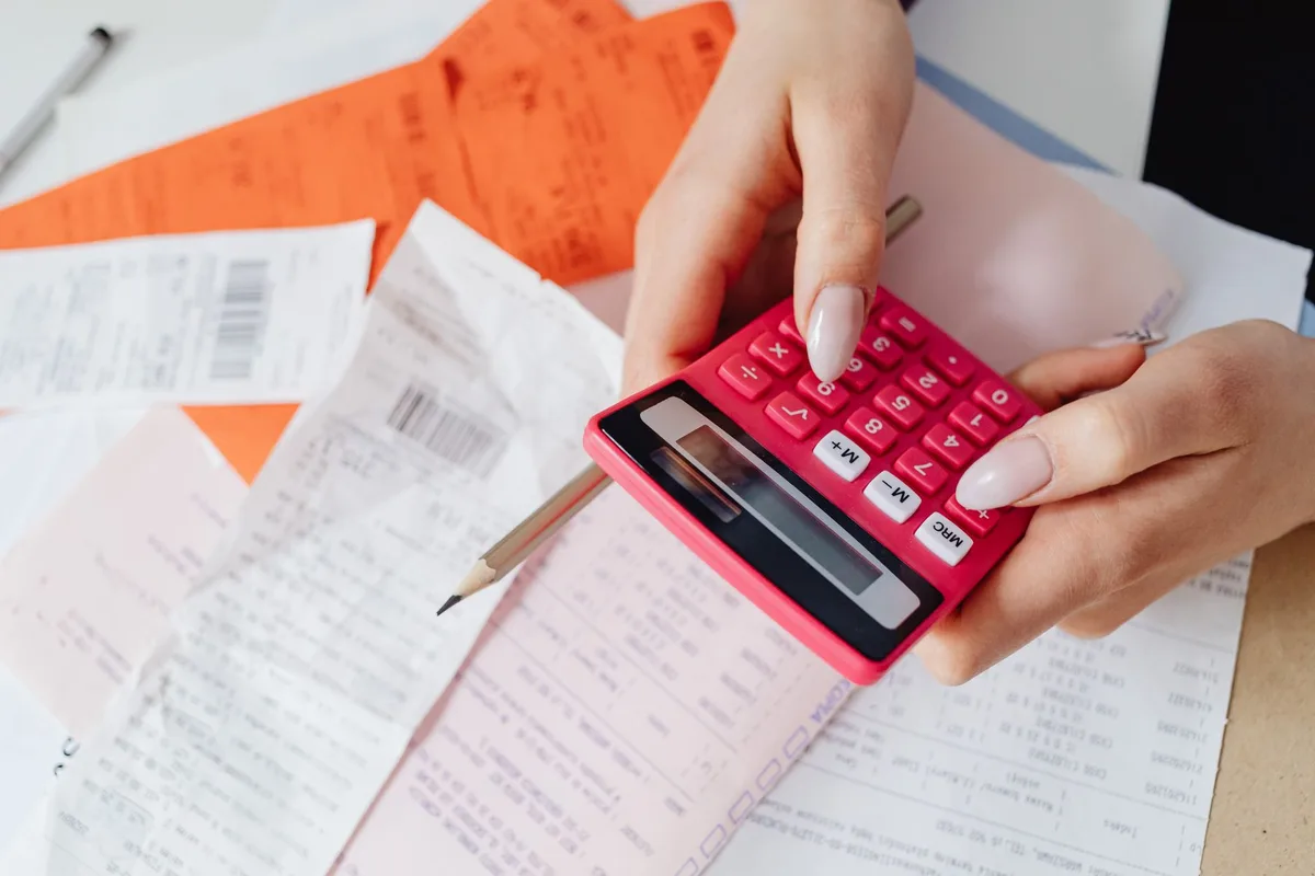 Personne calculant et analysant les factures énergétiques sur papier