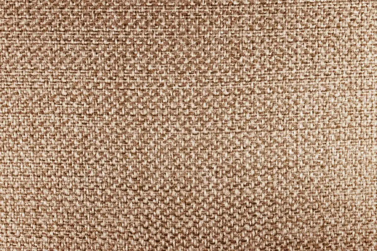 Détails de matériaux naturels : lin, bois brut, laine et fibres tissées pour une décoration bohème
