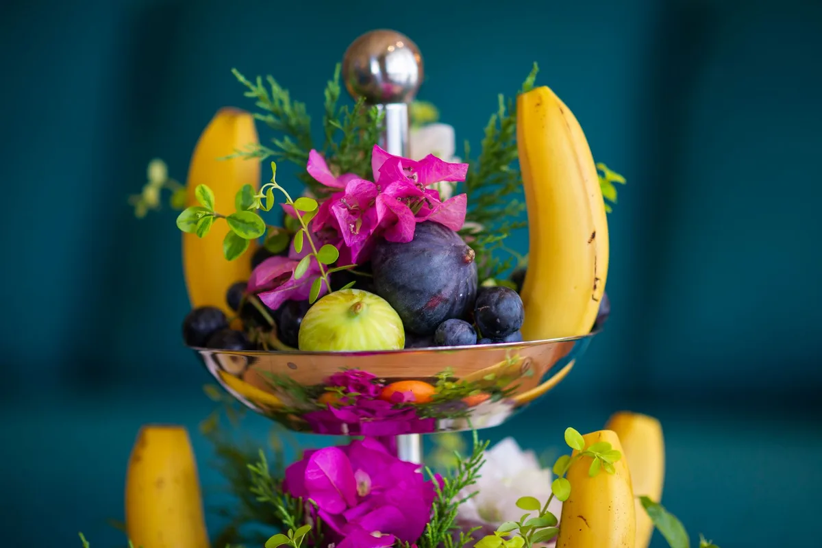 Centre de table avec fruits et fleurs mélangés pour un effet frais et abondant