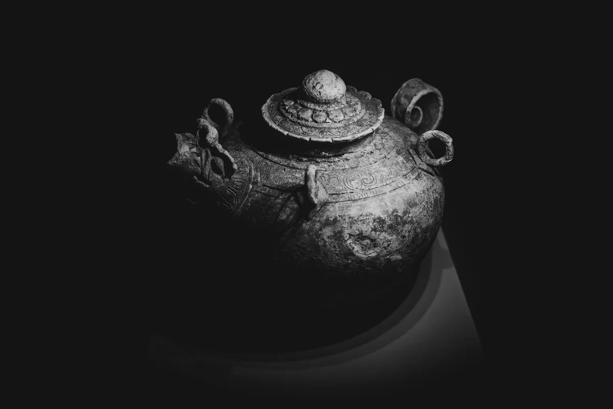 Vase et petite sculpture posés parmi des livres