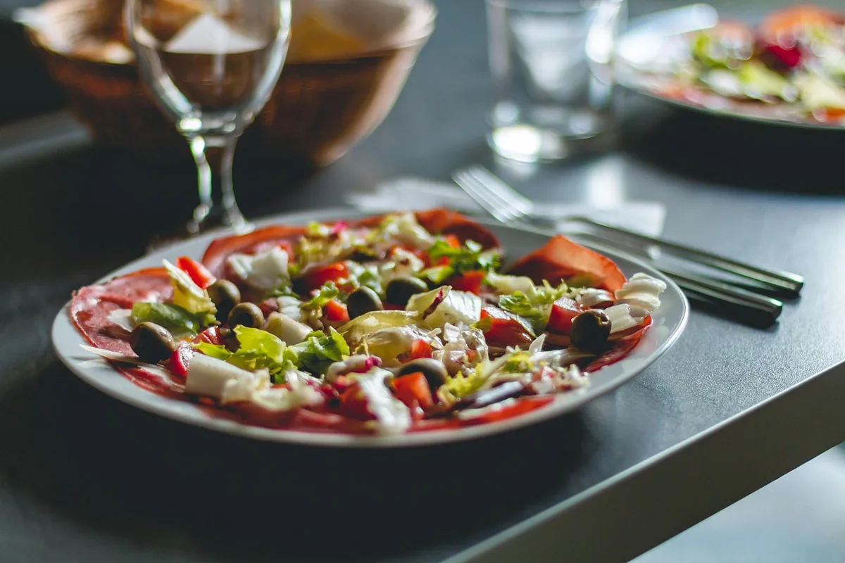Étagères ouvertes de cuisine bien rangées avec vaisselle et pots assortis