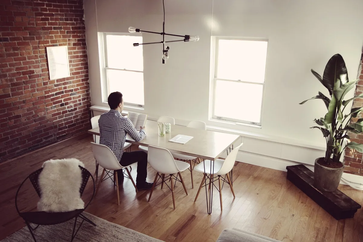 Espace rénové avec murs décapés et grandes fenêtres laissant entrer la lumière
