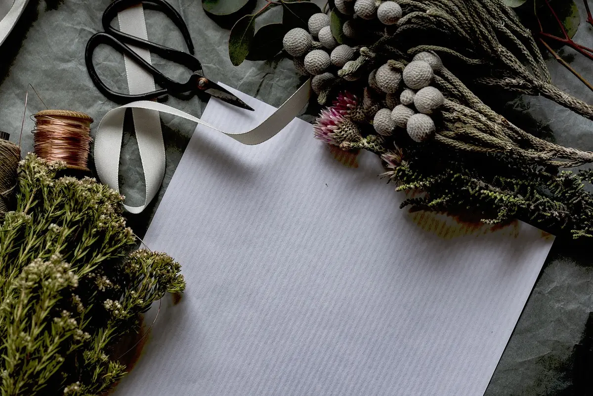 Matériel d'impression: imprimante, papier cartonné, ciseaux et ficelle posés sur une table